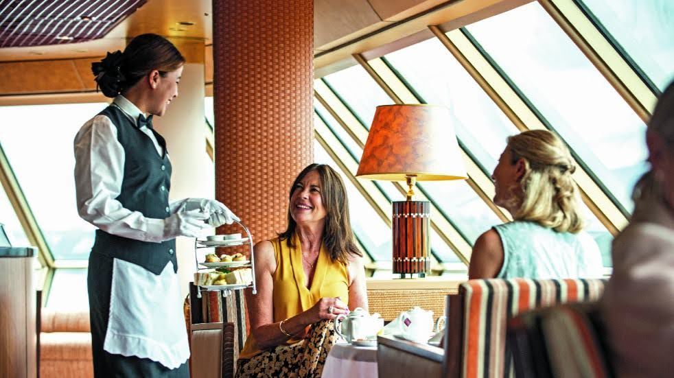 Waitress serving afternoon tea aboard a Fred Olsen cruise ship